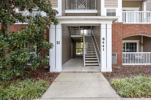 Front view of a building entrance with stairs leading to upper floors.