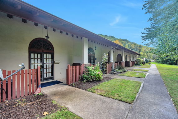 Front view of a single-story house with arched doorways and red fences.