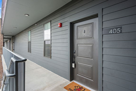 Exterior view of a building hallway with apartment doors.