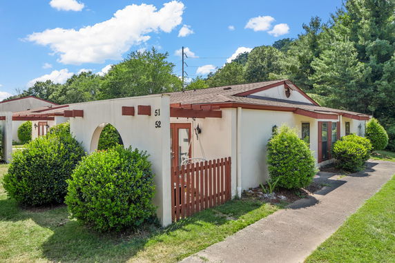 Front view of a single-story house with an archway and small gated entry.