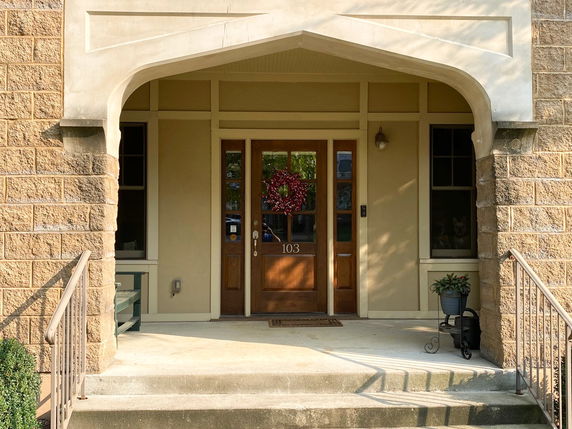Front view of a house entrance with a decorative door and small porch.
