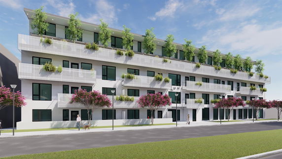 Front view of a multi-story building with balconies and greenery.