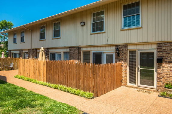 Front view of a two-story building with a fenced patio area.