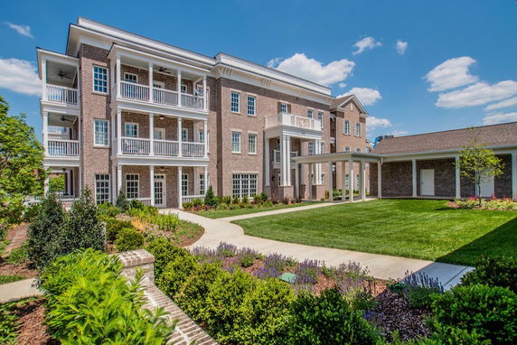 Front view of a multi-story brick apartment building with balconies.