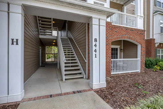 Front view of a multi-story building with an open stairway and brick facade.