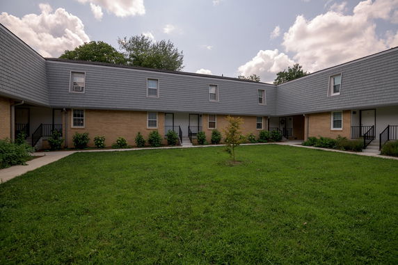 Front view of a two-story building with shingle siding and multiple entry doors.