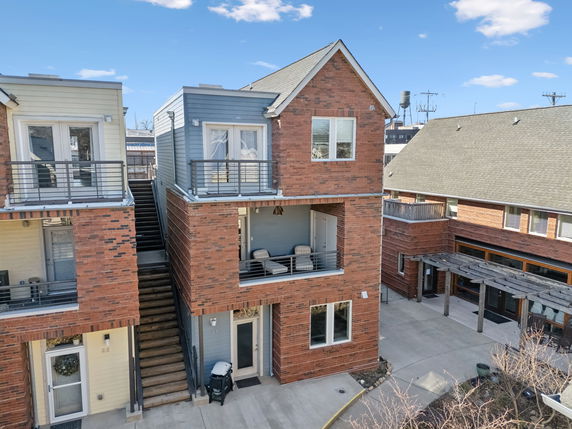 Front view of a multi-story residential building with brick facade and balconies.