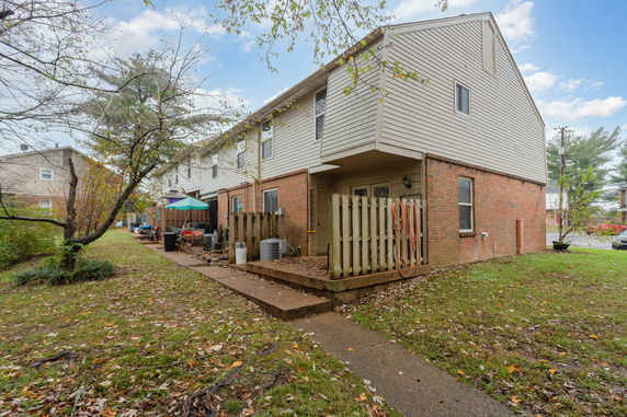 Side view of a two-story townhouse with brick and siding exterior.