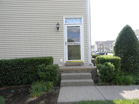 Front view of a house entrance with a small porch and steps.