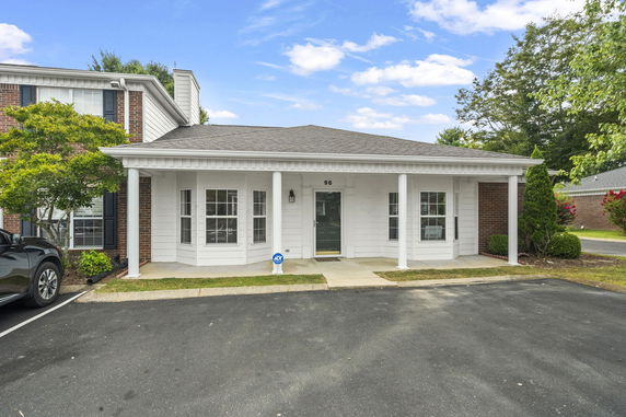 Front view of a single-story house with a covered porch and large windows.