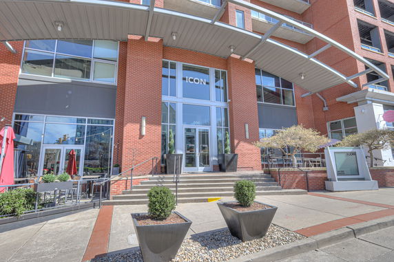 Front view of a multi-story building with large entrance and red brick exterior.
