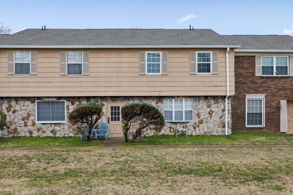 Front view of a two-story townhouse with a stone and siding facade.