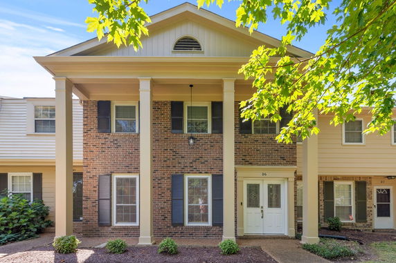 Front view of a two-story house with brick facade and white columns.