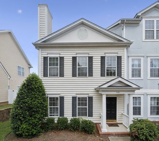 Front view of a two-story house with a chimney and columned entrance.