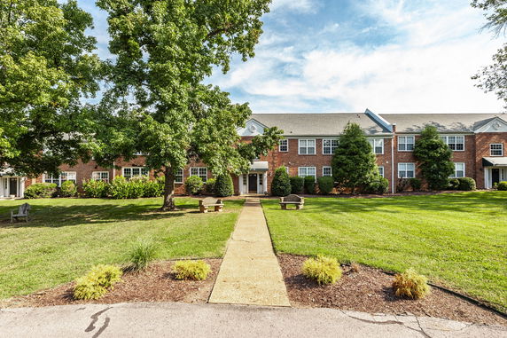 Front view of a two-story brick building with a lawn and pathway leading to the entrance.
