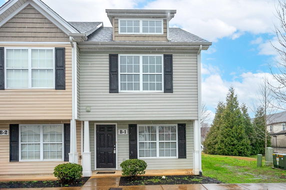 Front view of a two-story townhouse with a dormer window.
