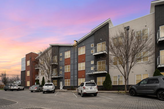 Front view of a multi-story apartment building with balconies.