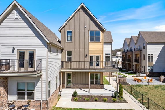 Front view of a multi-story house with large windows and a balcony.