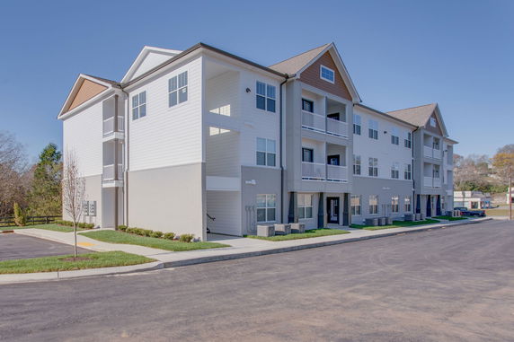 Front view of a multi-story apartment building with balconies.