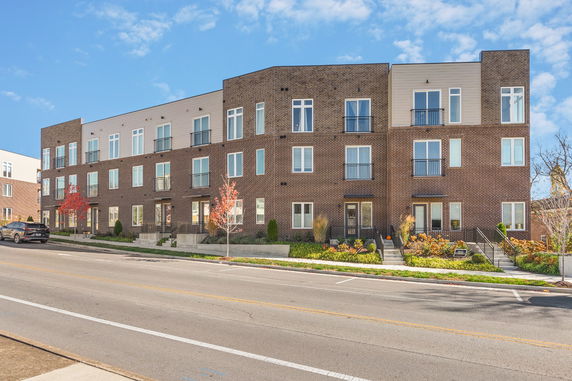 Front view of a modern three-story apartment building with brick exterior.