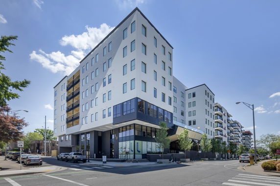 Front view of a multi-story building with modern design and balconies.