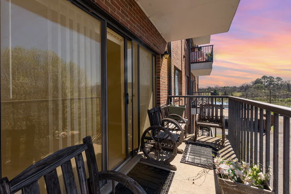 View from a balcony with wooden chairs and a scenic outdoor landscape.