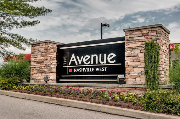 Front view of a building sign made of stone with 'The Avenue Nashville West' written on it.