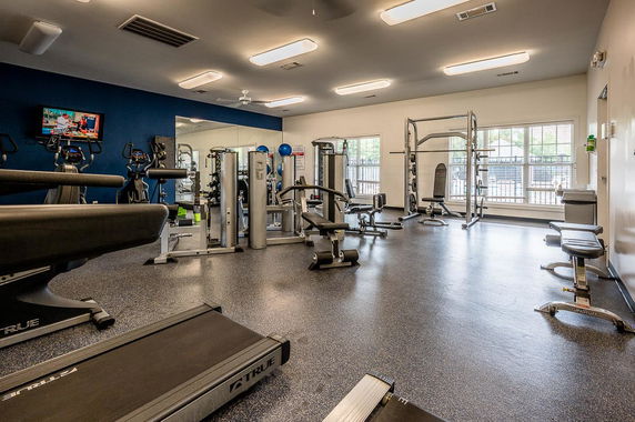 Room with various gym equipment and exercise machines.