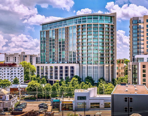 Front view of a tall multi-story building with large glass windows.