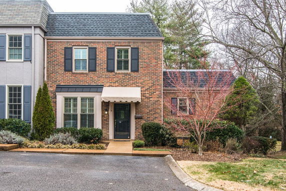 Front view of a two-story brick house with a front door awning.