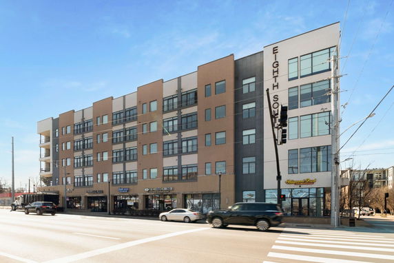 Front view of a multi-story building with commercial spaces on the ground floor.