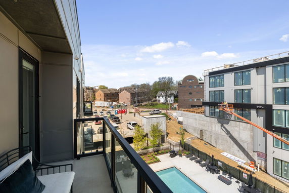Wide angle view of a construction site and surrounding buildings from a building balcony.