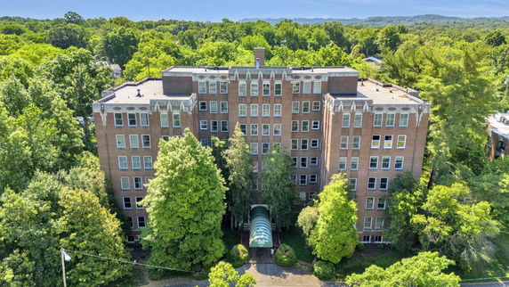 Front view of a multi-story brick building with multiple windows.