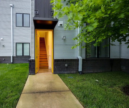 Entrance view of a building with a path leading to a stairway.
