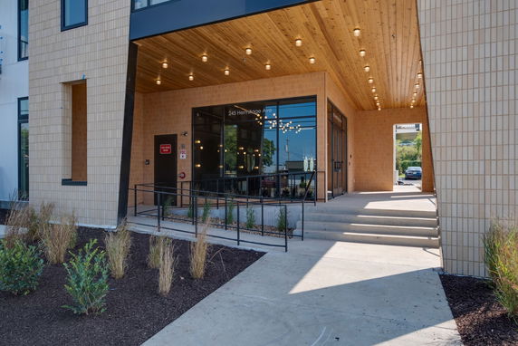 Front view of a modern entrance with stairs and lighting.
