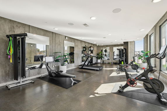 Interior view of a fitness area with exercise equipment and mirrors.