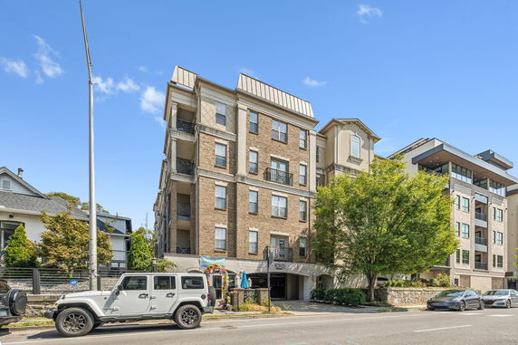Front view of a multi-story apartment building with balconies.