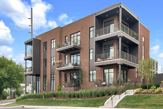 Front view of a modern multi-story brick building with balconies.