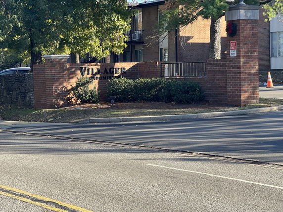 Front view of a residential building with brick signage at the entrance.