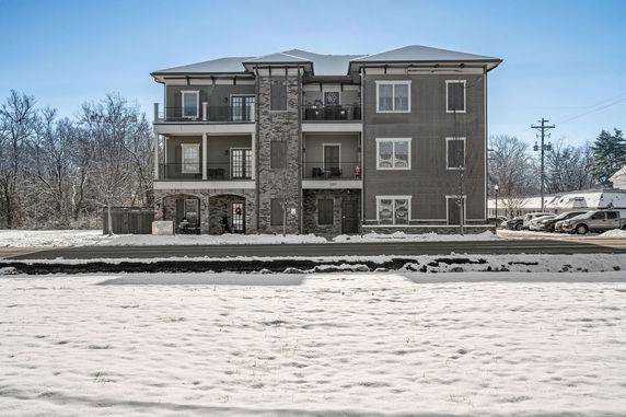 Front view of a multi-story apartment building with balconies.