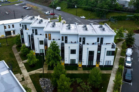 Front view of a multi-story residential building complex with multiple units and balconies.