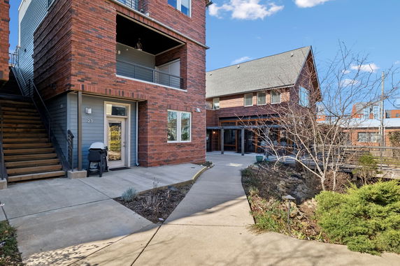 Front view of a brick residential building with an entrance and a staircase.