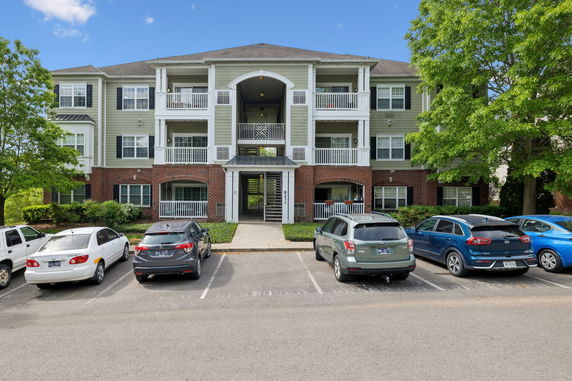 Front view of a three-story apartment building with balconies.