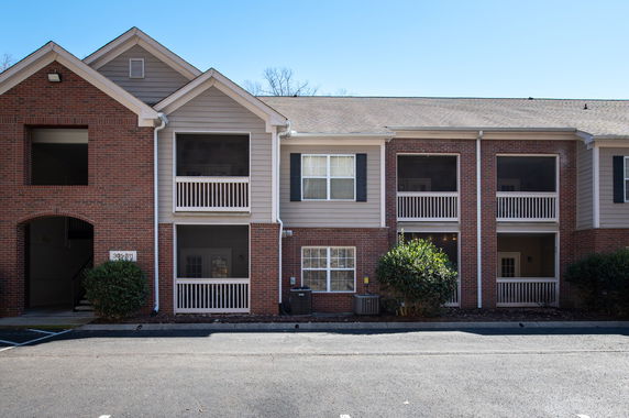 Front view of a two-story apartment building with brick facade and balconies.