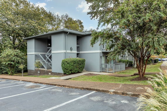 Front view of a two-story residential building with balconies and external stairs.
