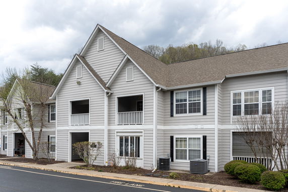 Front view of a two-story residential building with gable roofs and balconies.