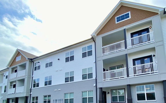 Front view of a multi-story residential building with balconies.