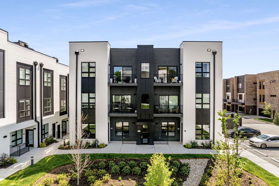Front view of a modern three-story apartment building with balconies.