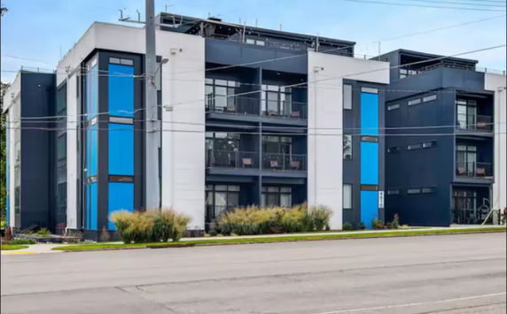 Front view of a modern apartment building with blue and white facade.