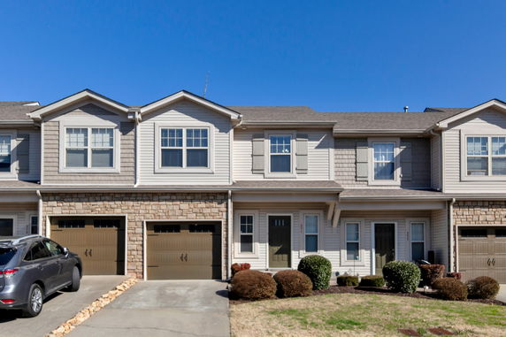 Front view of a two-story townhouse with an attached garage.